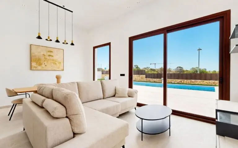 Een moderne en lichte woonkamer in een smart home met grote ramen en uitzicht op het zwembad aan de Costa Blanca.