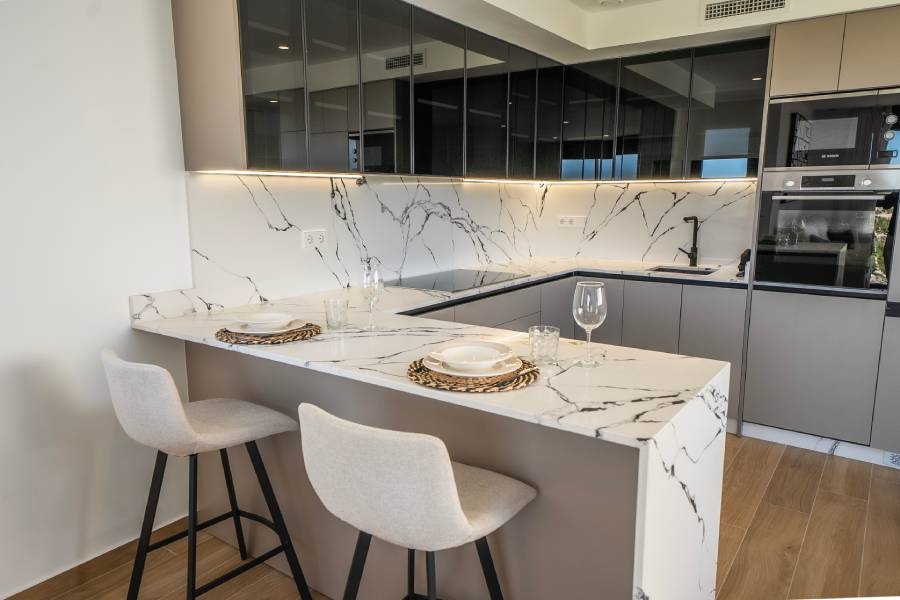 Modern kitchen with an island, marble-effect worktop and contemporary finishes in a luxury villa